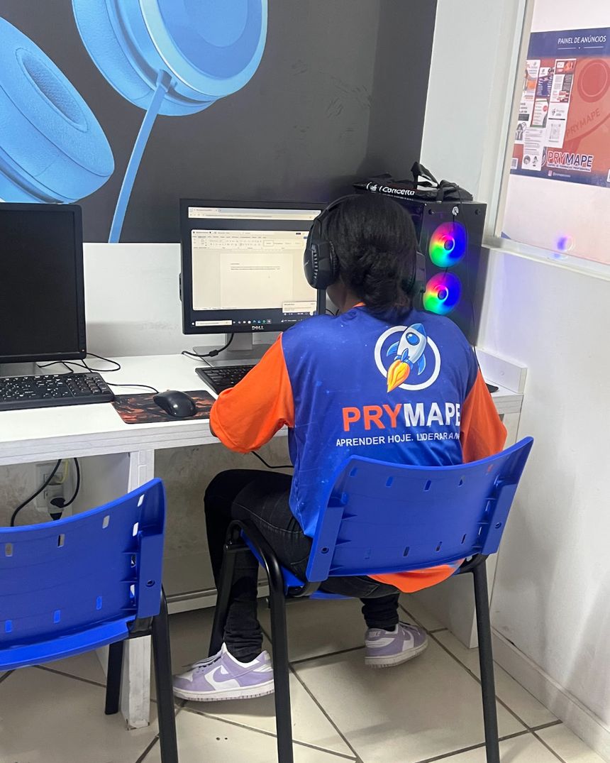 Aluna com o uniforme da Prymape em aula no laboratório de informática